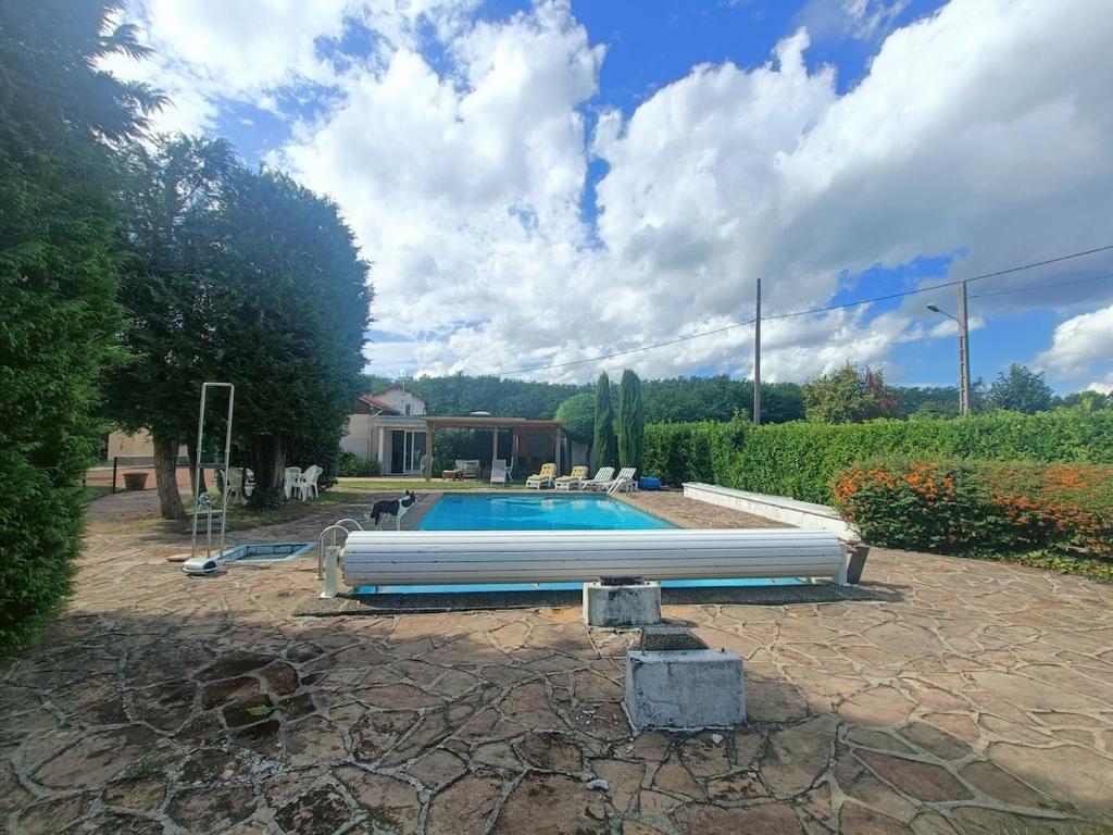 a swimming pool in a yard next to a house at L escapade de l'Ancien Rail in Pouilly-sous-Charlieu