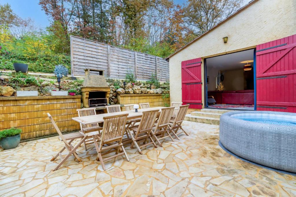 a patio with a table and chairs and a pool at La Gardère - Villa Sarlat in Sarlat-la-Canéda
