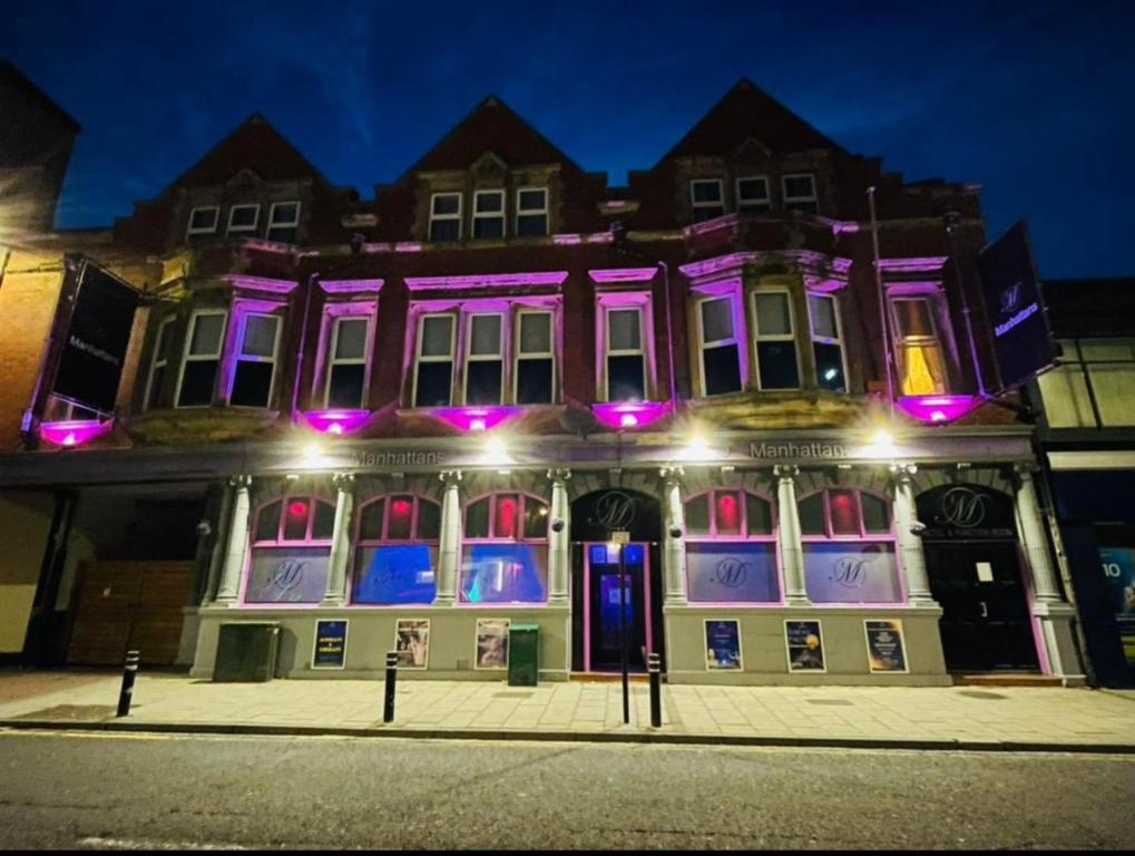 a building with purple lights on the front of it at izzy hotel ltd in Old Walker