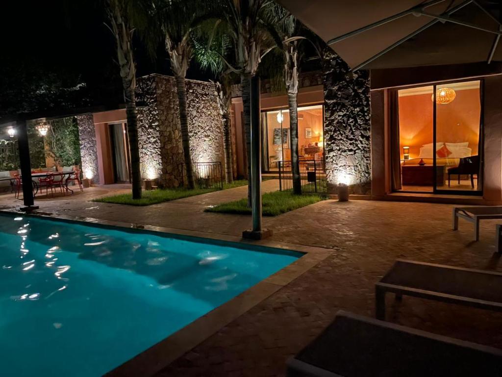 una piscina frente a una casa por la noche en Villa Dar Waw Marrakech, en Tameslouht