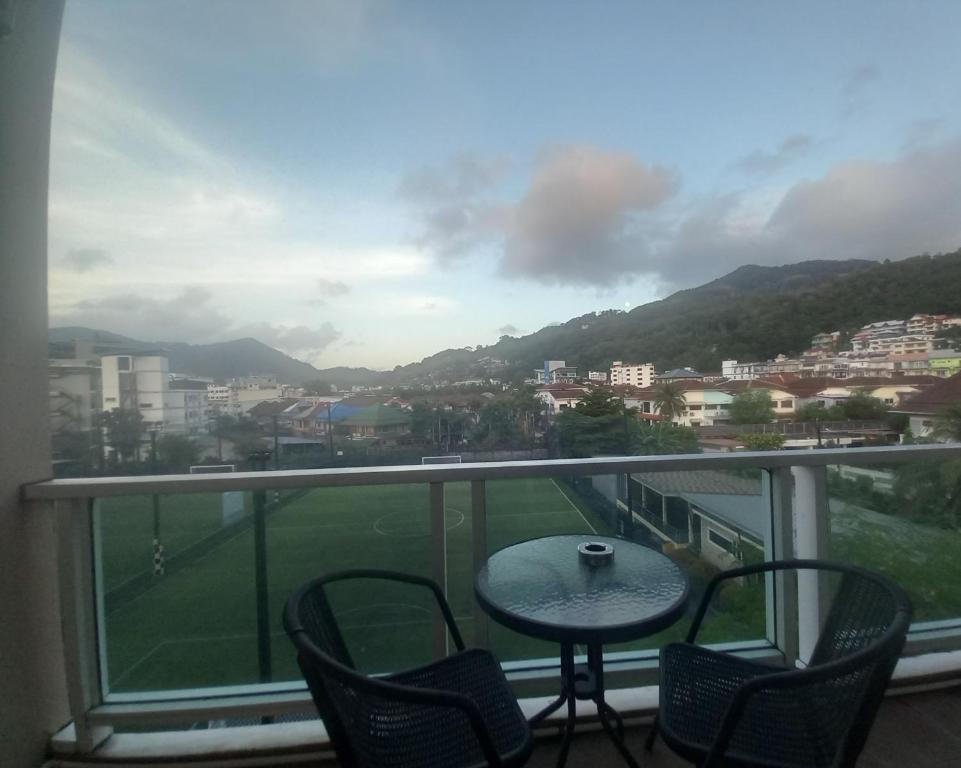 een balkon met een tafel en stoelen en uitzicht op een stad bij Lucky3star in Patong Beach