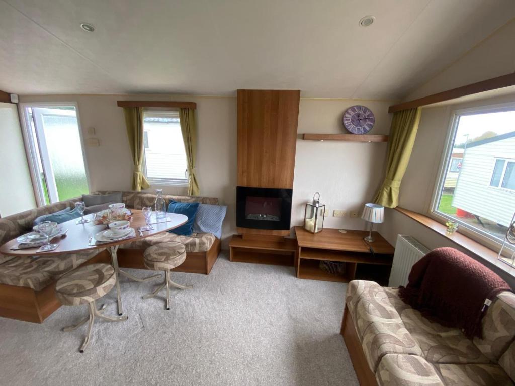 ein Wohnzimmer mit Tisch und Couch in der Unterkunft Lovely 6 Berth Caravan Nearby Hunstanton Beach In Norfolk Ref 23020T in Hunstanton