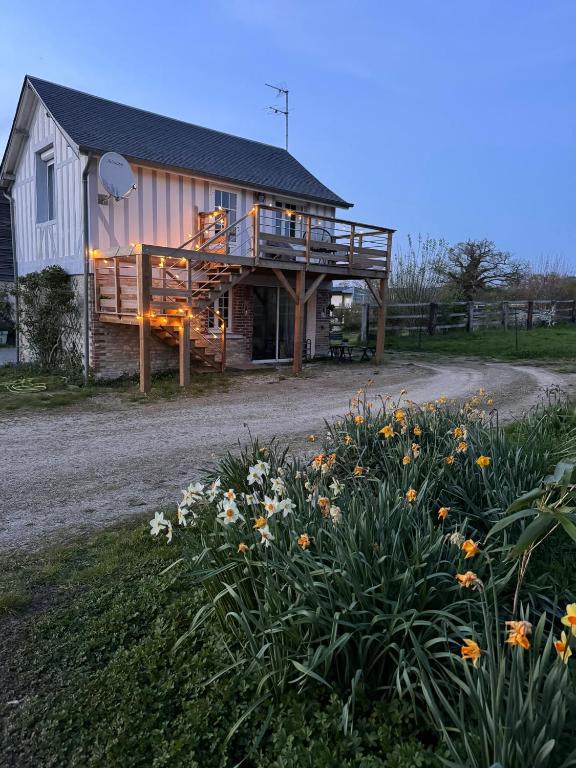 a house with a deck on the side of it at Gîte dans un petit haras in Mézidon