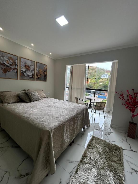 a bedroom with a bed and a large window at Apartamento grande em Santa Teresa-ES in Santa Teresa