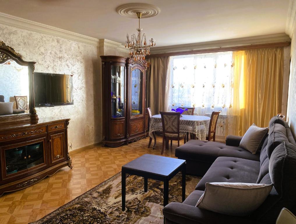 a living room with a couch and a table at Sunrise Apartment Gai Avenue One, Yerevan in Yerevan