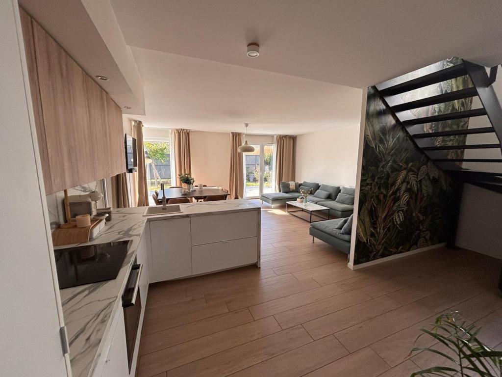 een keuken en een woonkamer met een trap in een huis bij Échappée Alsacienne in Illzach