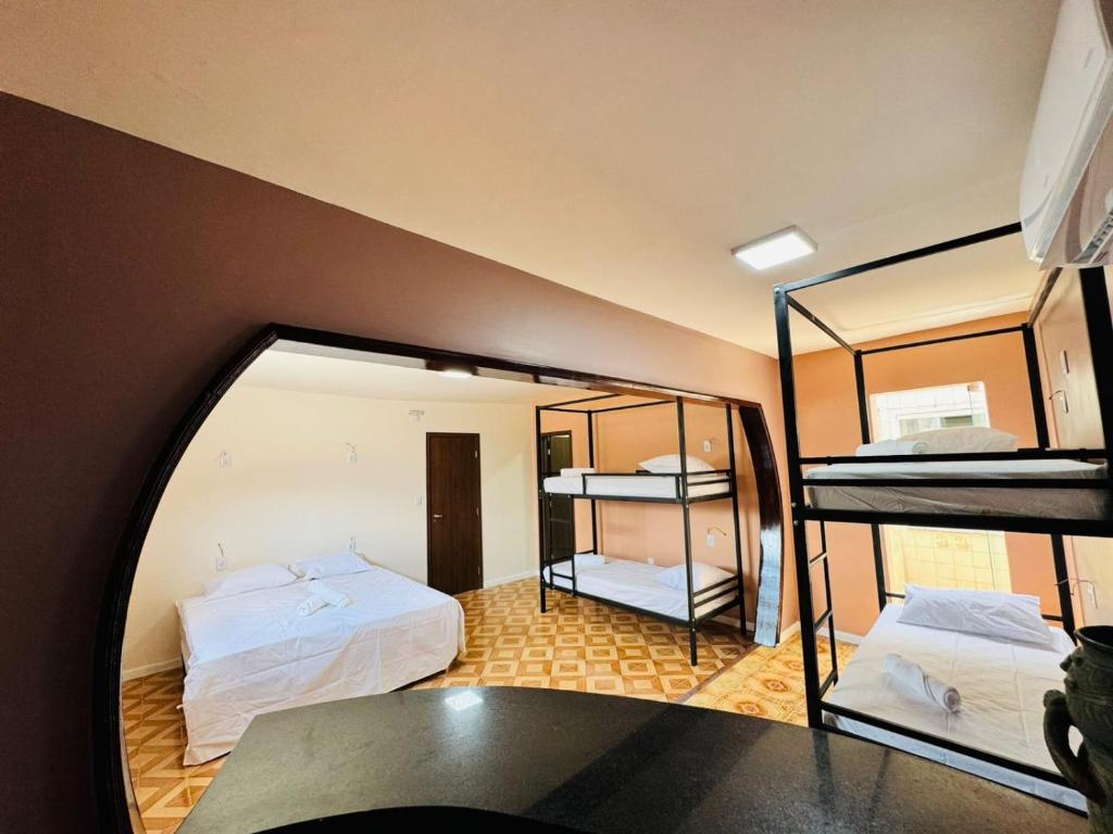 Muira Stay Belém Hostel في بيليم: غرفة بسريرين بطابقين ومرآة