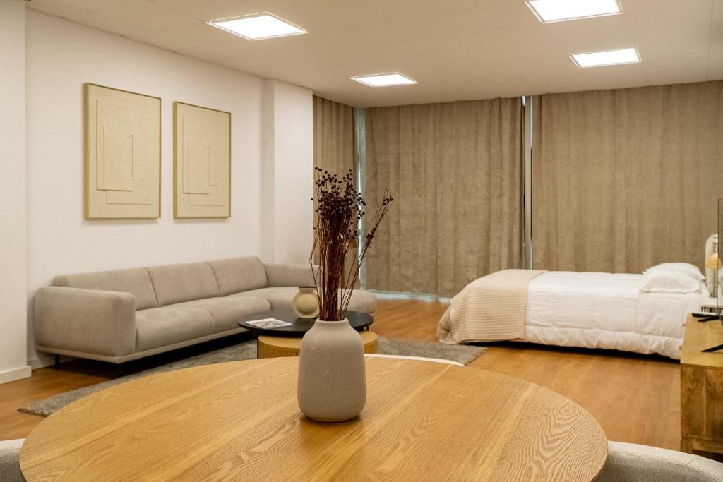 een woonkamer met een tafel en een bed bij Business office - Studio with garage in Linda-a-Velha