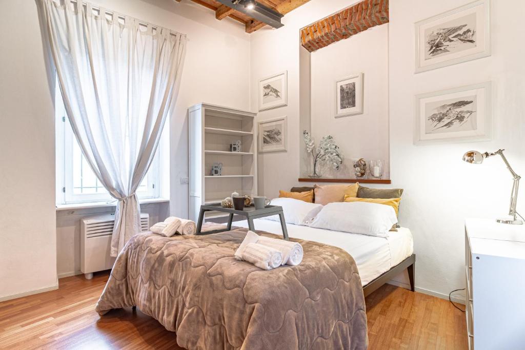a white bedroom with a bed and a window at Suite Manzoni by Houset in Monza