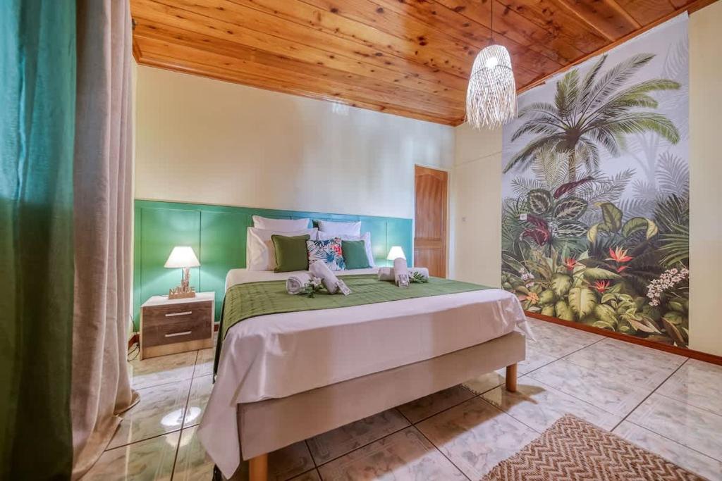 a bedroom with a bed with two stuffed animals on it at Kaz Latania in Étang-Salé