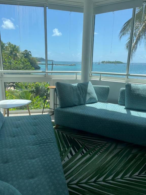 a living room with a couch and a view of the ocean at Guadeloupe Ilet Gosier best view in Le Gosier