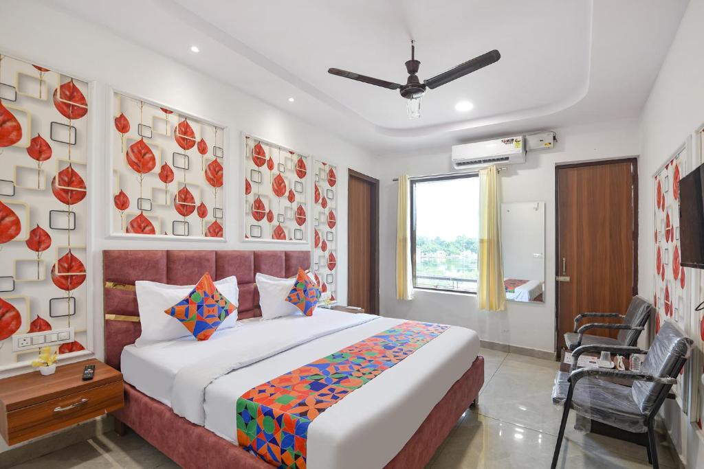a bedroom with a bed and a chair in it at FabHotel AB Residency in Ludhiana