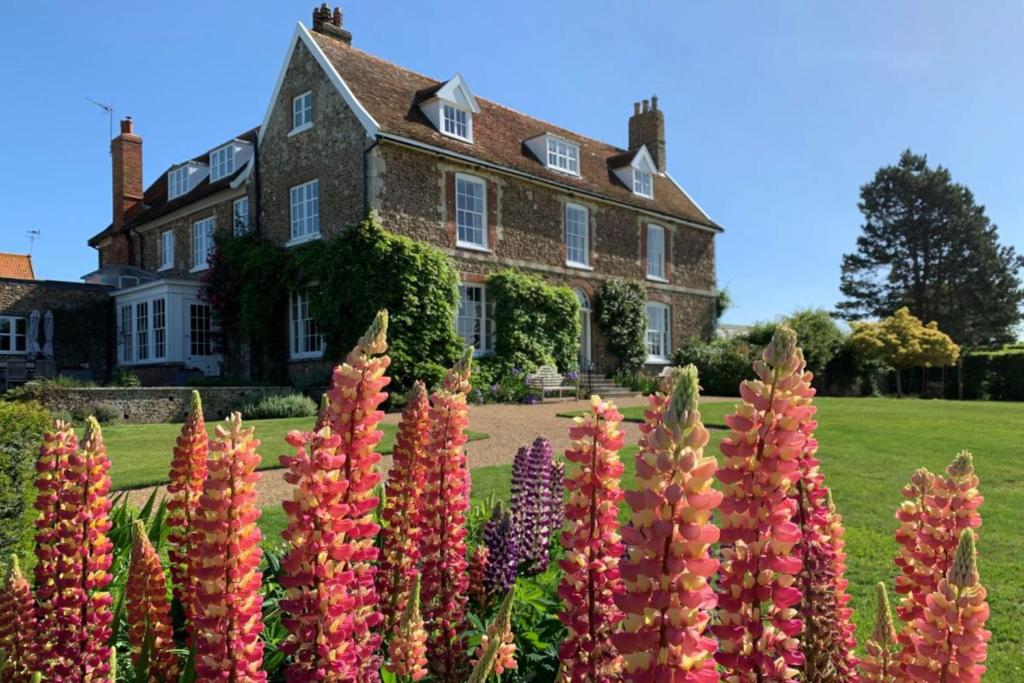 a house with a bunch of flowers in front of it at Butley Priory Farmhouse in Woodbridge