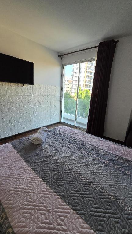 a bedroom with a large bed with a large window at Large apartment close to everything! North area in Cochabamba
