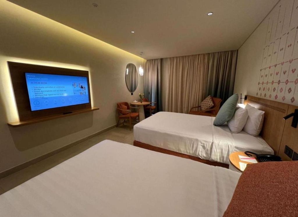 カイロにあるrizakyan pyramids view INNのベッド2台と薄型テレビ付きのホテルの部屋