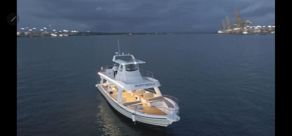 a white boat floating in the water at night at Yate PORTOBELO LUXURY in Buenaventura