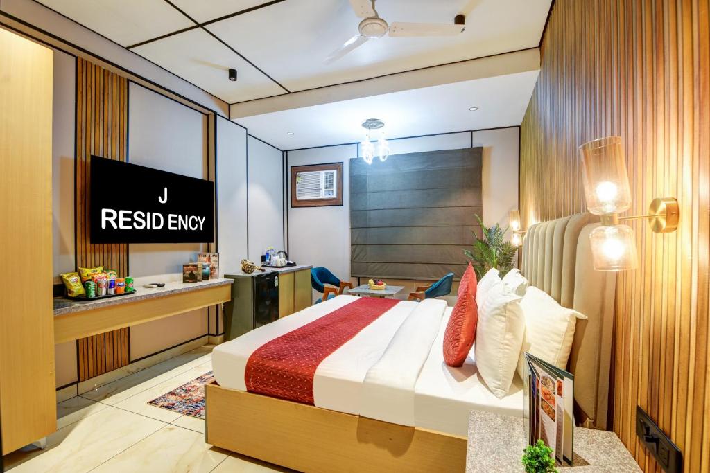una habitación de hotel con una cama y un escritorio en J Residency Near Nizamuddin Railway Station, en Nueva Delhi