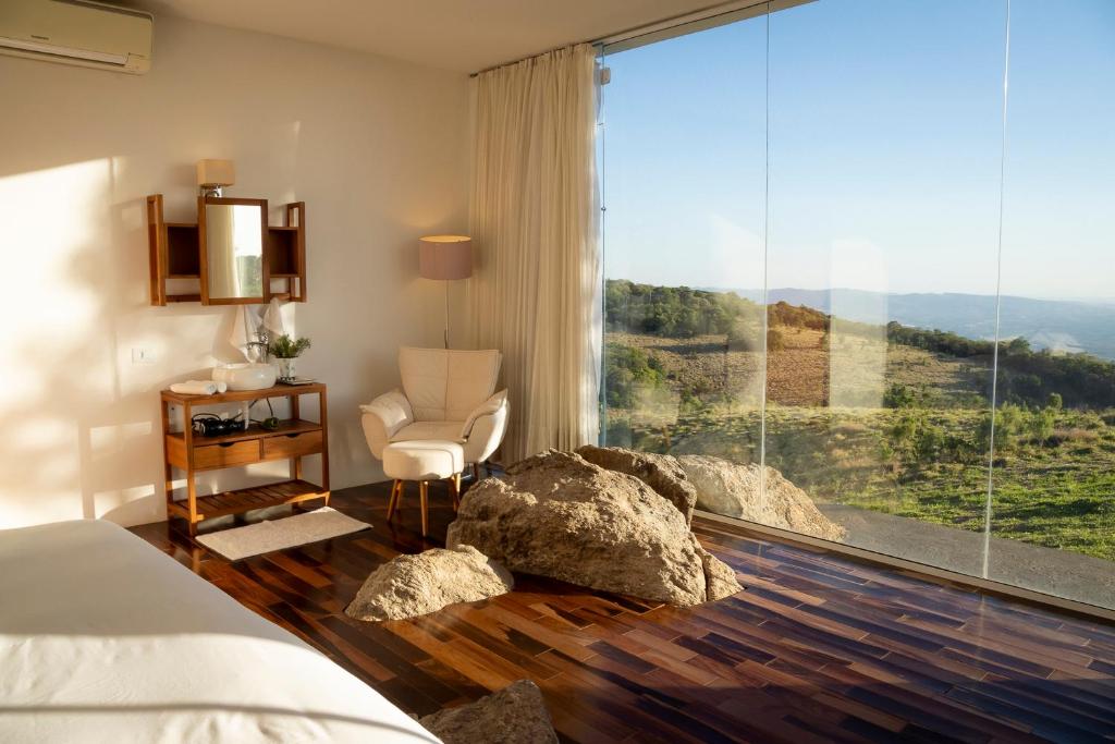 a bedroom with a bed and a large window at Cabana Pico do Gavião in Andradas