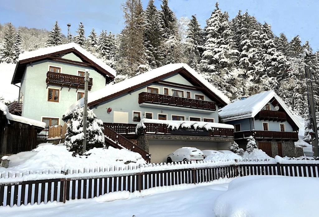 a house with a fence in the snow at Penzión Liezky in Mýto pod Ďumbierom