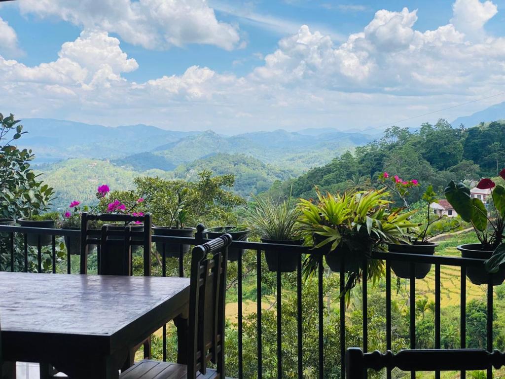 a balcony with a table and potted plants at Cloudora Inn Kandy in Kandy