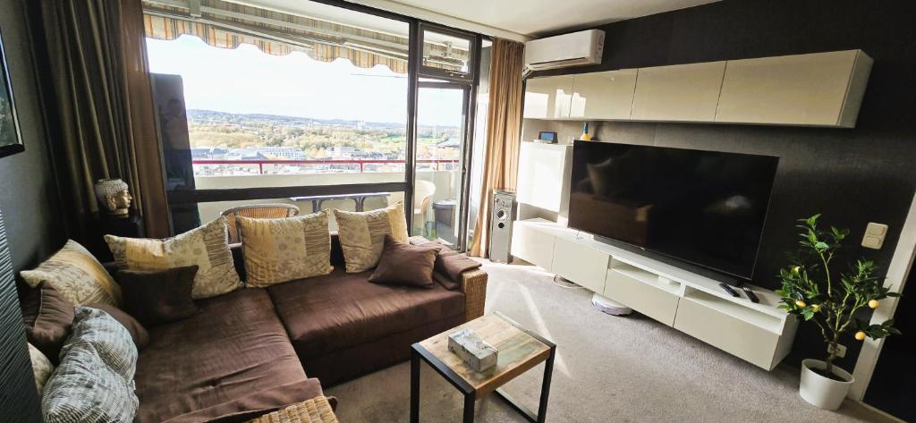 een woonkamer met een bank en een grote televisie bij Let's RelaxX 60QM Free parking in Mülheim an der Ruhr