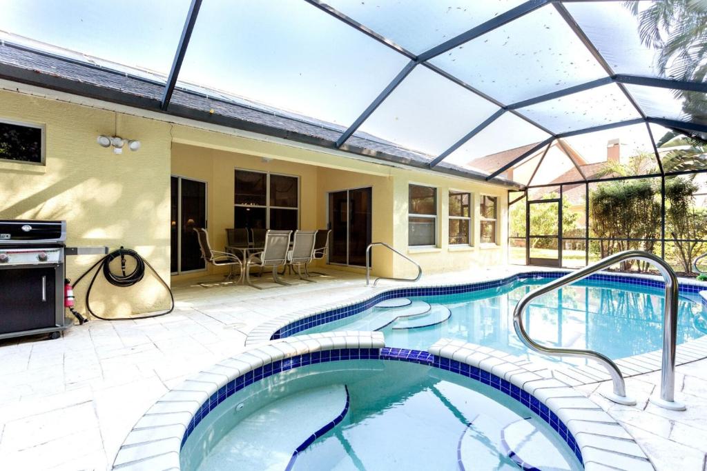 una piscina cubierta con techo de cristal en SERENE & ATTRACTIVE 3BR HEATED POOL/SPA HOME, en Estero