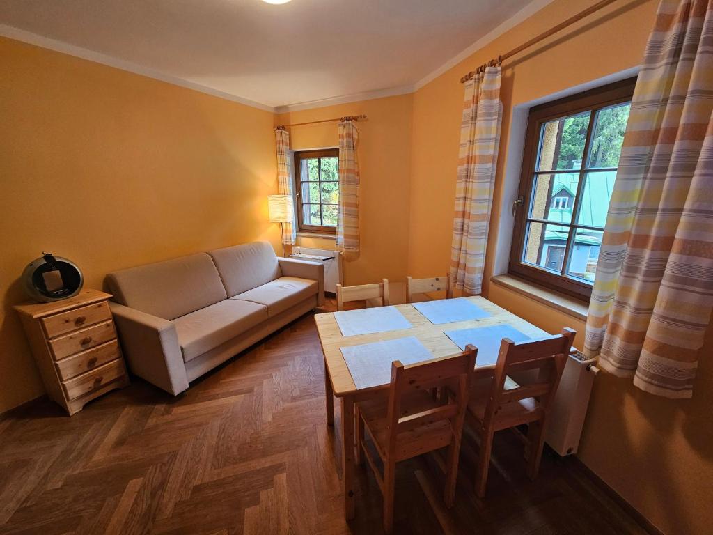 a living room with a couch and a table at Rodinný apartmán Pec pod Sněžkou 3 - 1x parking available in Pec pod Snezkou