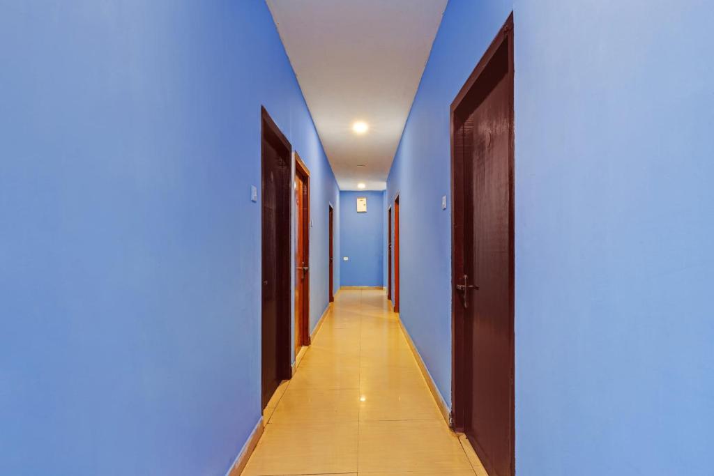 a hallway with blue walls and a long corridor at Hotel O New Jebii's Inn in Kāhārpāra