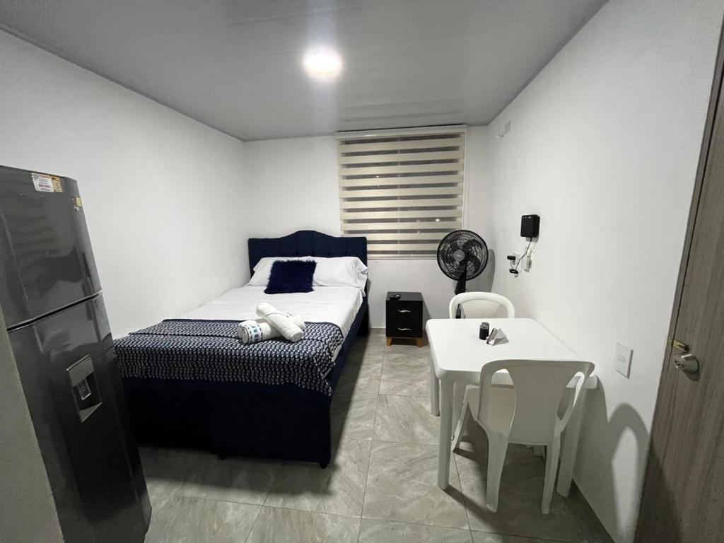 ein kleines Schlafzimmer mit einem Bett und einem Tisch und Stühlen in der Unterkunft Apartaestudio Vacacional en Girardot, piscinas, Jacuzis, parqueadero para moto in Girardot