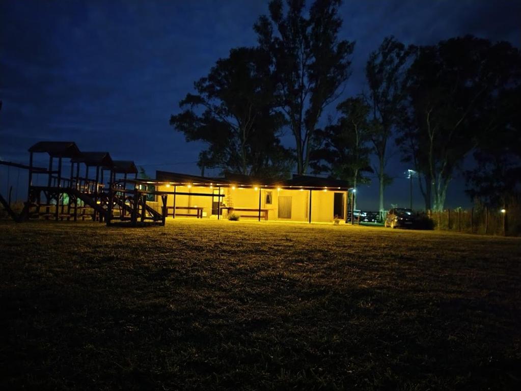 a building with lights in a field at night at Poyecto Laguna in San Miguel del Monte