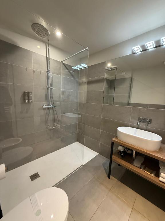 Un baño con ducha, lavabo e inodoro. en Malvezzi24 Boutique Rooms, en Desenzano del Garda