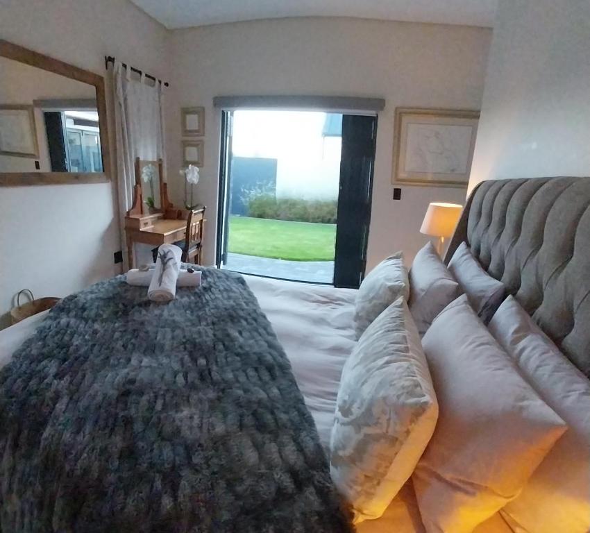 a bedroom with a large bed and a couch at White Feather Guest Room and Wellness Spa in Yzerfontein