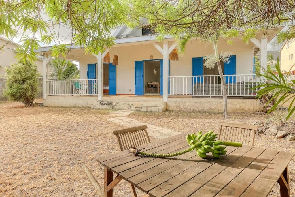 een houten picknicktafel voor een huis bij Kaz Nautilia in La Saline Les hauts 