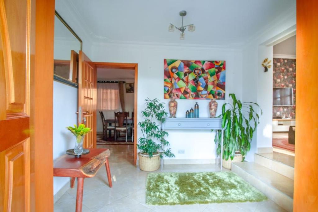 un salon avec une cheminée et un tableau au mur dans l'établissement Tara Villa - Elegant 4-Bedroom Home in Buziga - Kampala, à Kampala