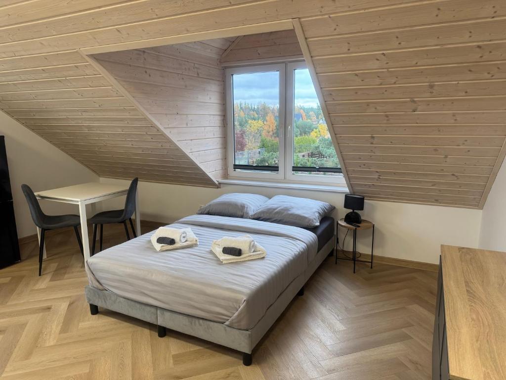 a bedroom with a bed with two towels on it at Przystanek Niesiołowice - na Kaszubach in Niesiołowice