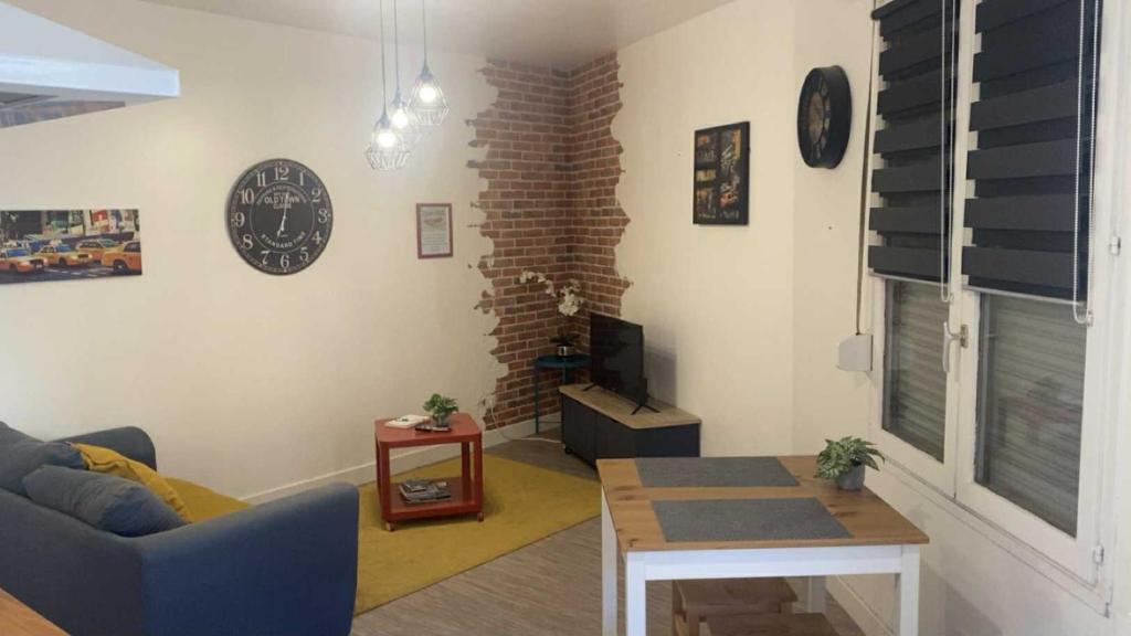 een woonkamer met een bank en een tafel bij La Hestia à 2 pas du Château in Sedan