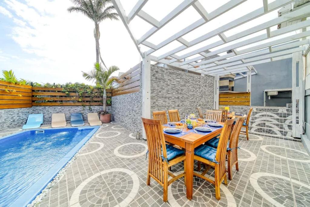 a patio with a table and chairs next to a swimming pool at Kaz d Abord in Saint-Pierre