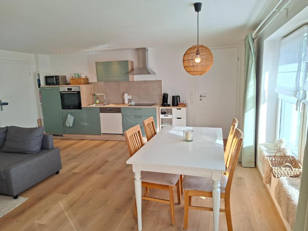 eine Küche und ein Wohnzimmer mit Tisch und Stühlen in der Unterkunft Ferienwohnung Luise unterhalb der Burg Lindenfels in Lindenfels