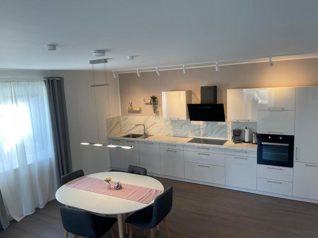 a kitchen with a table and chairs and a kitchen with white cabinets at Casa Antonius in Lebach