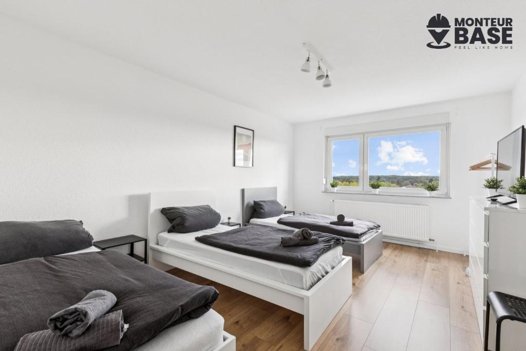Una habitación blanca con dos camas y una ventana. en MONTEUR - Unterkunft für bis zu 6 Personen in 63454 Hanau - HU11, en Hanau am Main