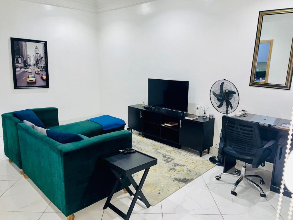 sala de estar con sofá verde y escritorio en Modern 1bedroom in Bodija, en Ibadán