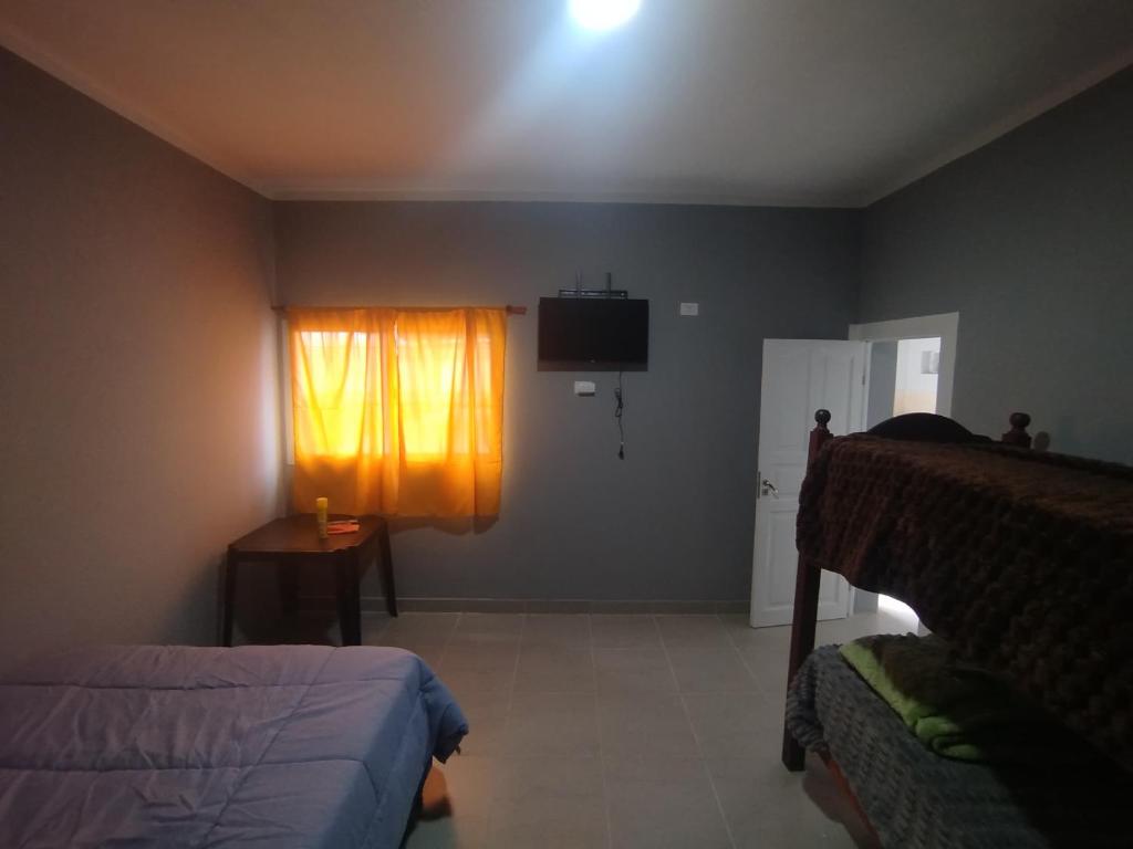 een slaapkamer met een bed, een raam en een televisie bij Quincho balderrama 