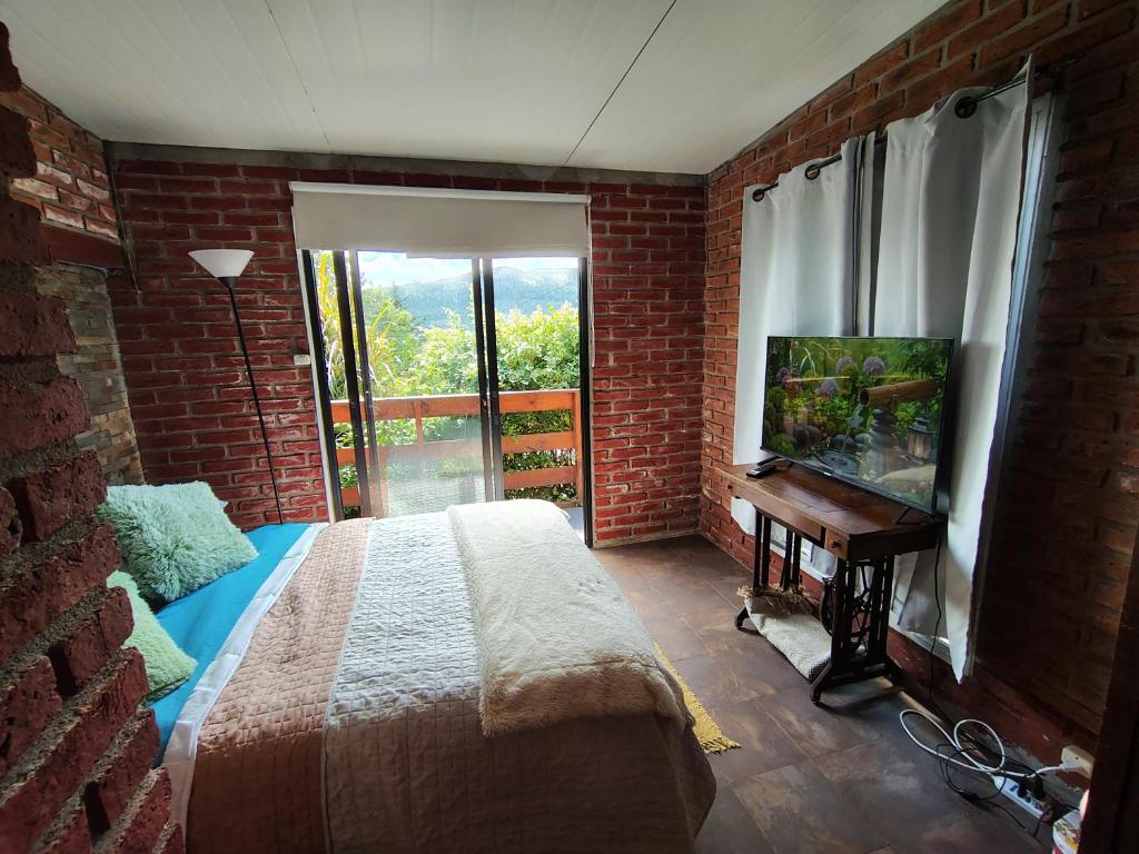 a bedroom with a bed and a window and a television at Vinoteca cerro in Piriápolis