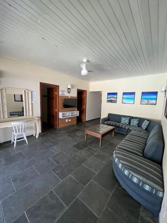 ein Wohnzimmer mit Sofa und Tisch in der Unterkunft Casa na praia do Guaiuba in Guarujá