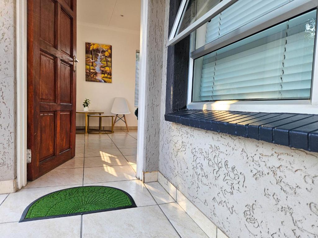 a door of a house with a green mat in front of a window at The M GuestHouse in Kempton Park
