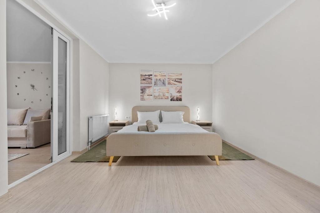 una camera da letto bianca con un letto e un divano di Casa Albă a Roman