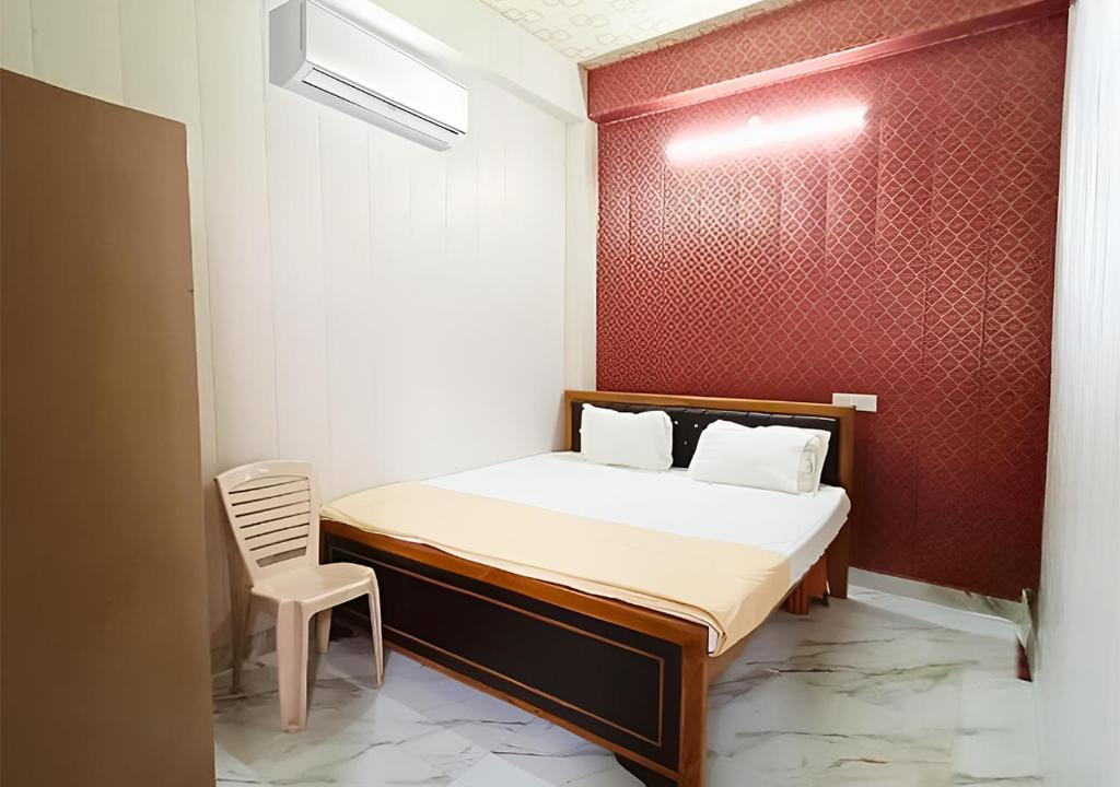 a small bedroom with a bed and a chair at Hotel Saraswati Palace in Varanasi