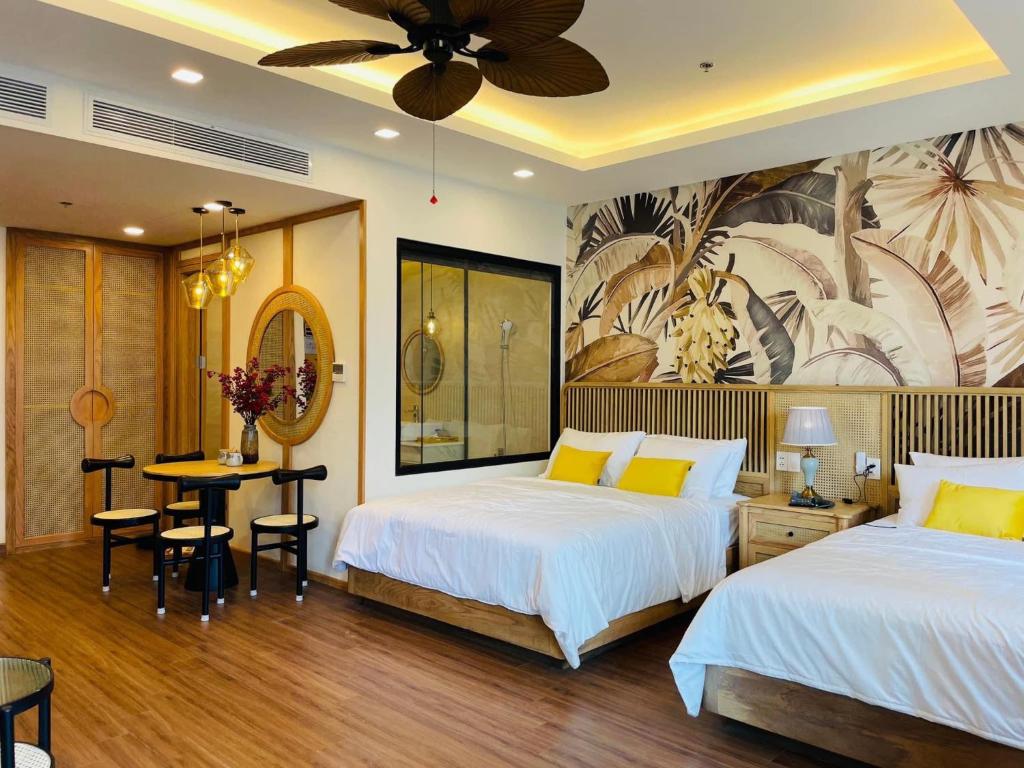 a hotel room with two beds and a table and a dining room at FLC Sea Tower - Sea view Quy Nhơn in Quy Nhon