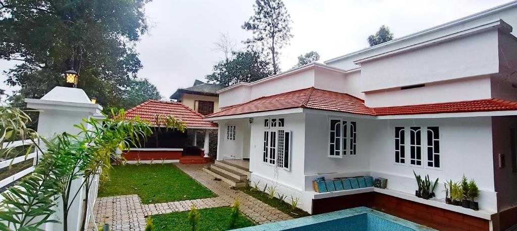 a house with a pool in front of it at Heaven Cloud Stay Hub Attappadi in Attappādi