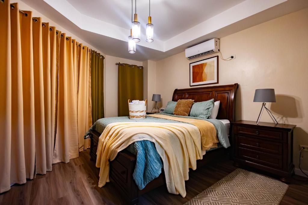 a bedroom with a bed with yellow curtains at 3 Bdr Apartment close to Port of Spain in Diego Martin